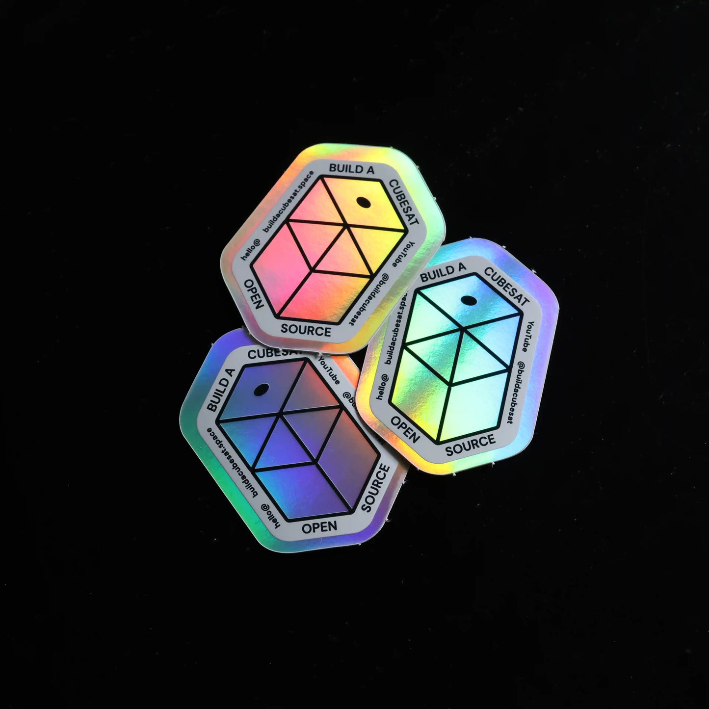 Three colorful geometric stickers on a black background