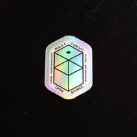 Holographic sticker with geometric design and text on a black background