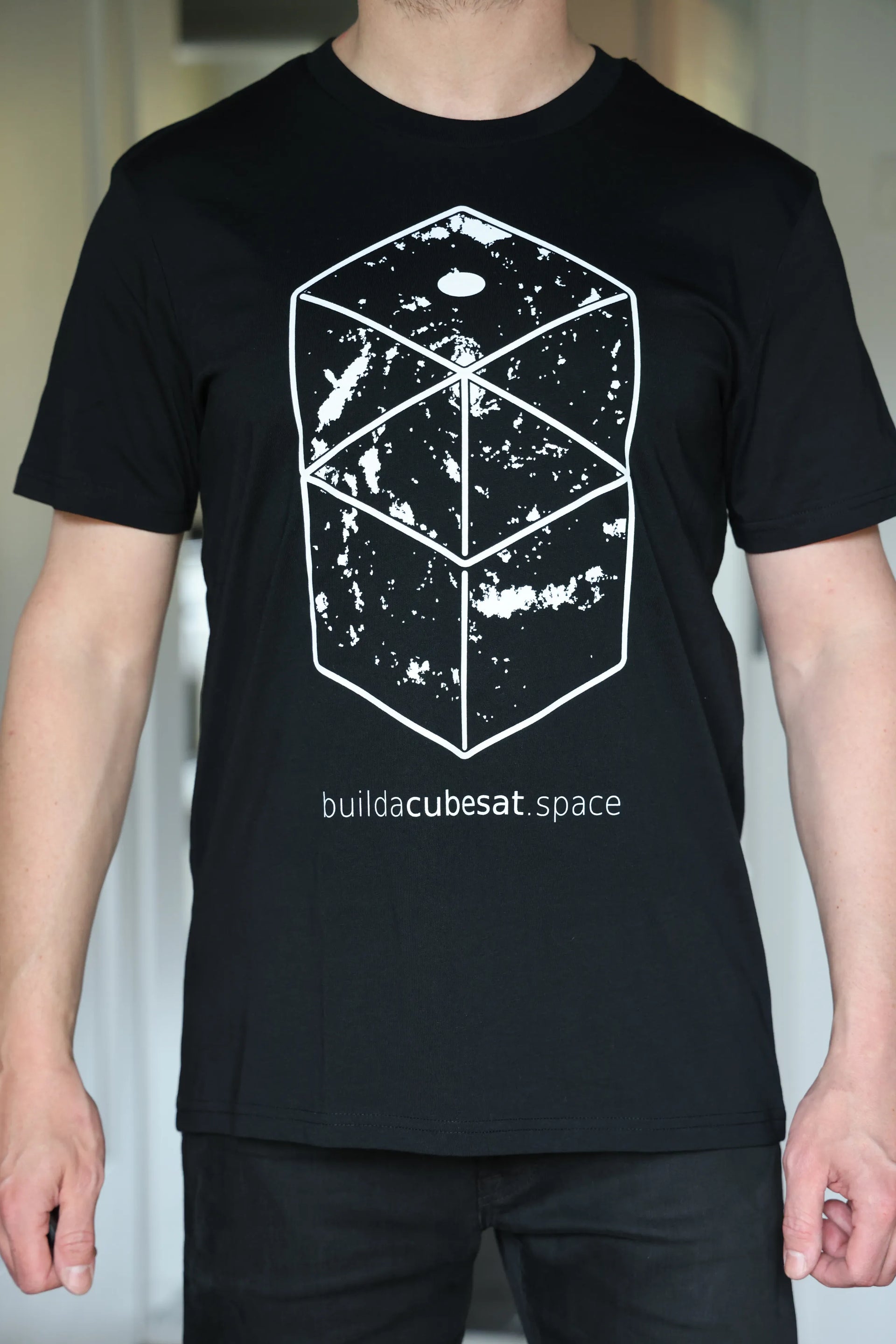 Black t-shirt with white geometric galaxy design and text on a plain background