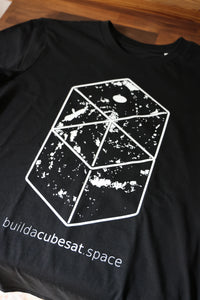 Black t-shirt with a white geometric galaxy design and text on a wooden surface